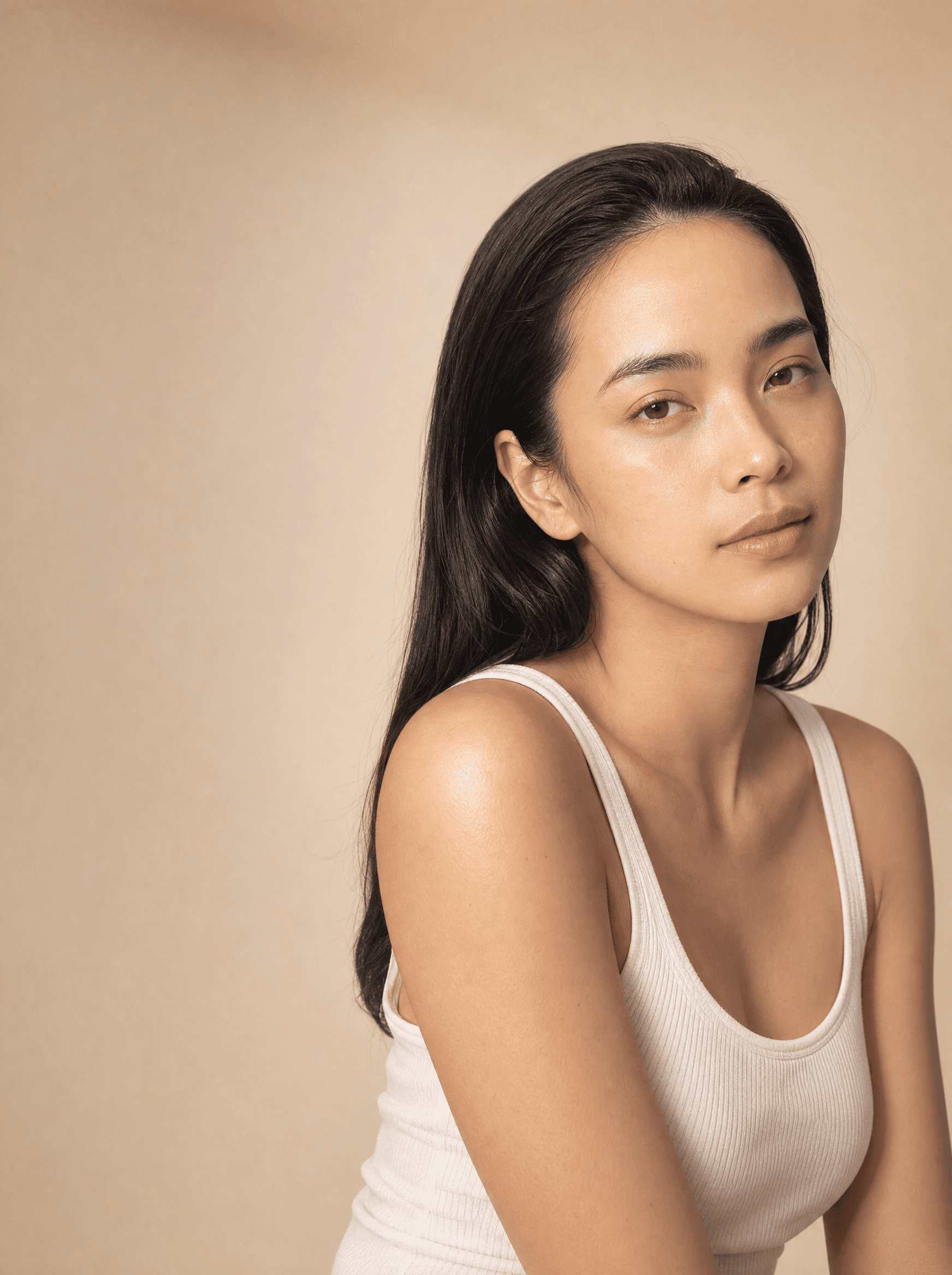 Close portrait in warm side light against a sand backdrop